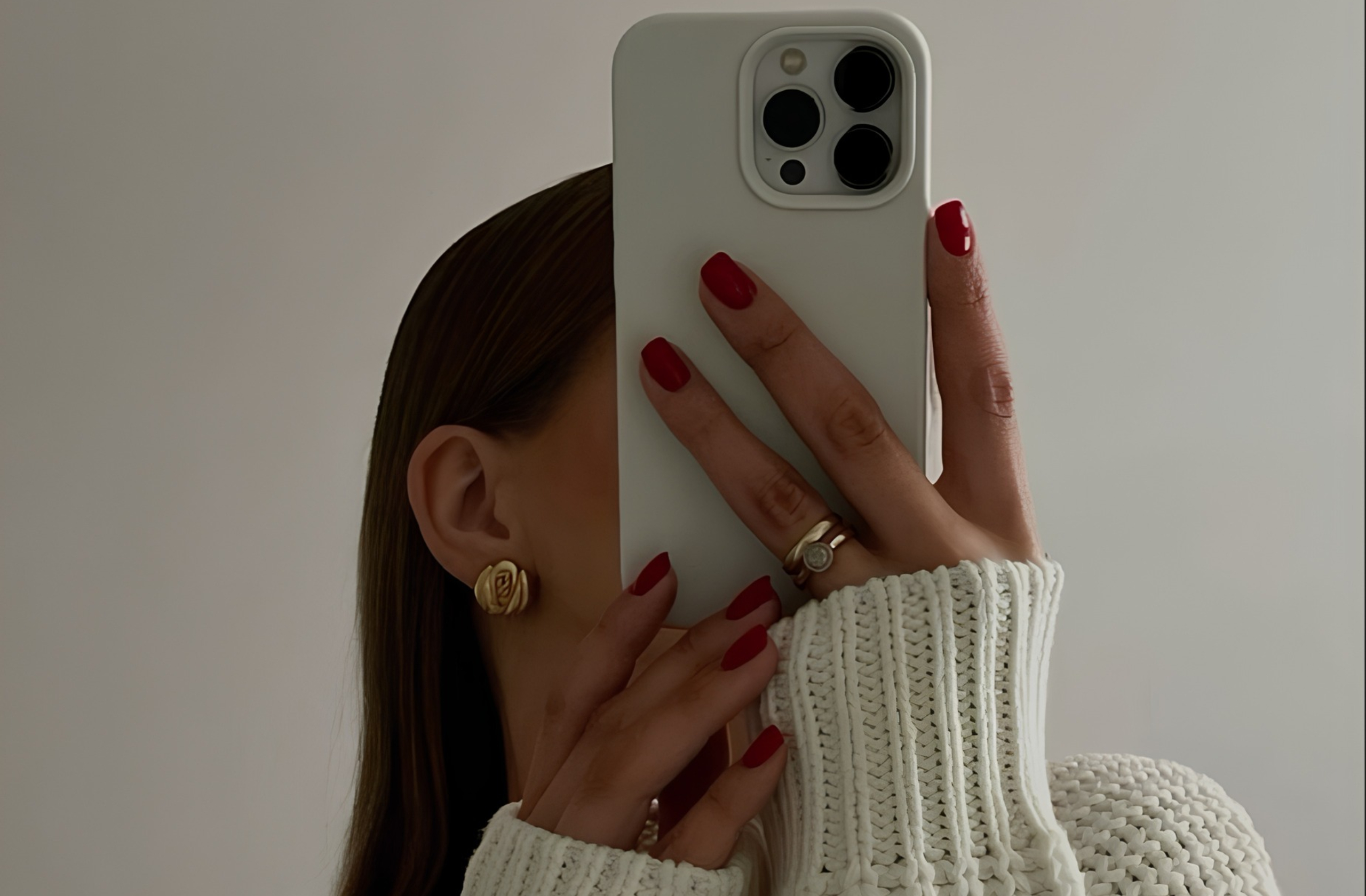 Žena drži mobilni telefon, pretražujući sadržaj o nezi kože.